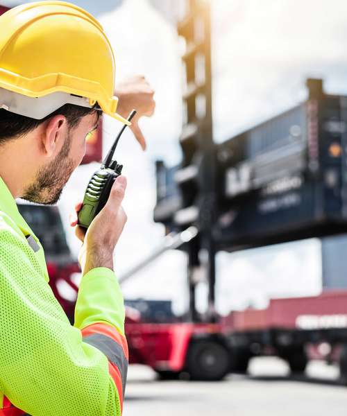 Image of Port worker with crane and lorrry