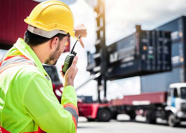 Image of Port worker with crane and lorrry